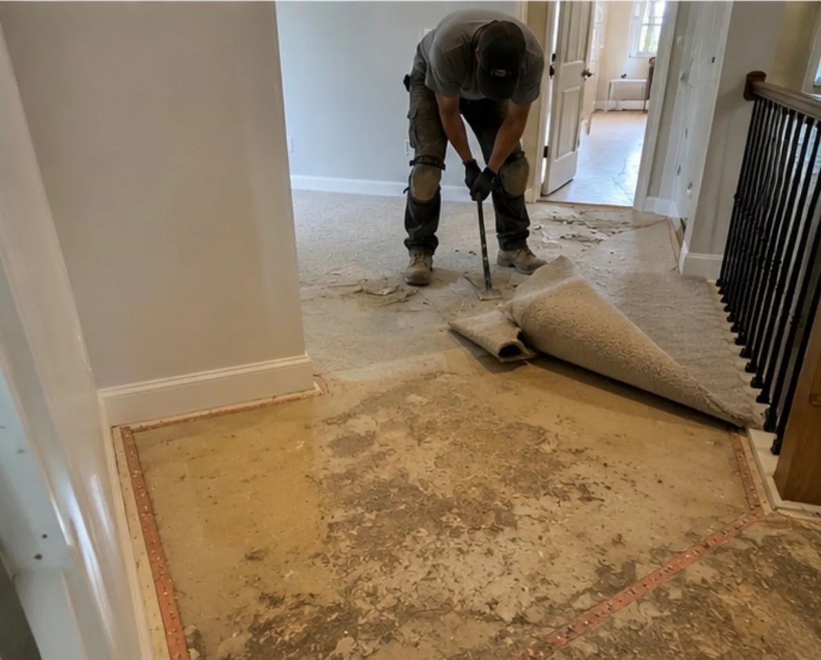 Installer pulling up old carpet and pad before a new floor goes in